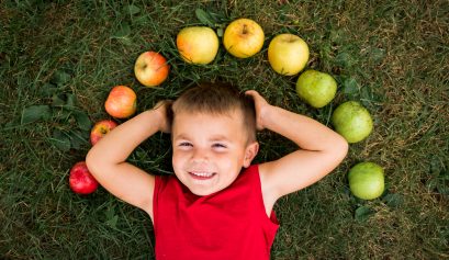 Child laying on ground under Apple rainbow