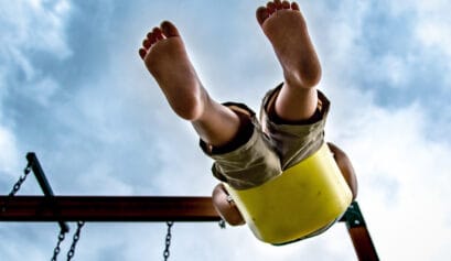 Ground up point of view of child swinging