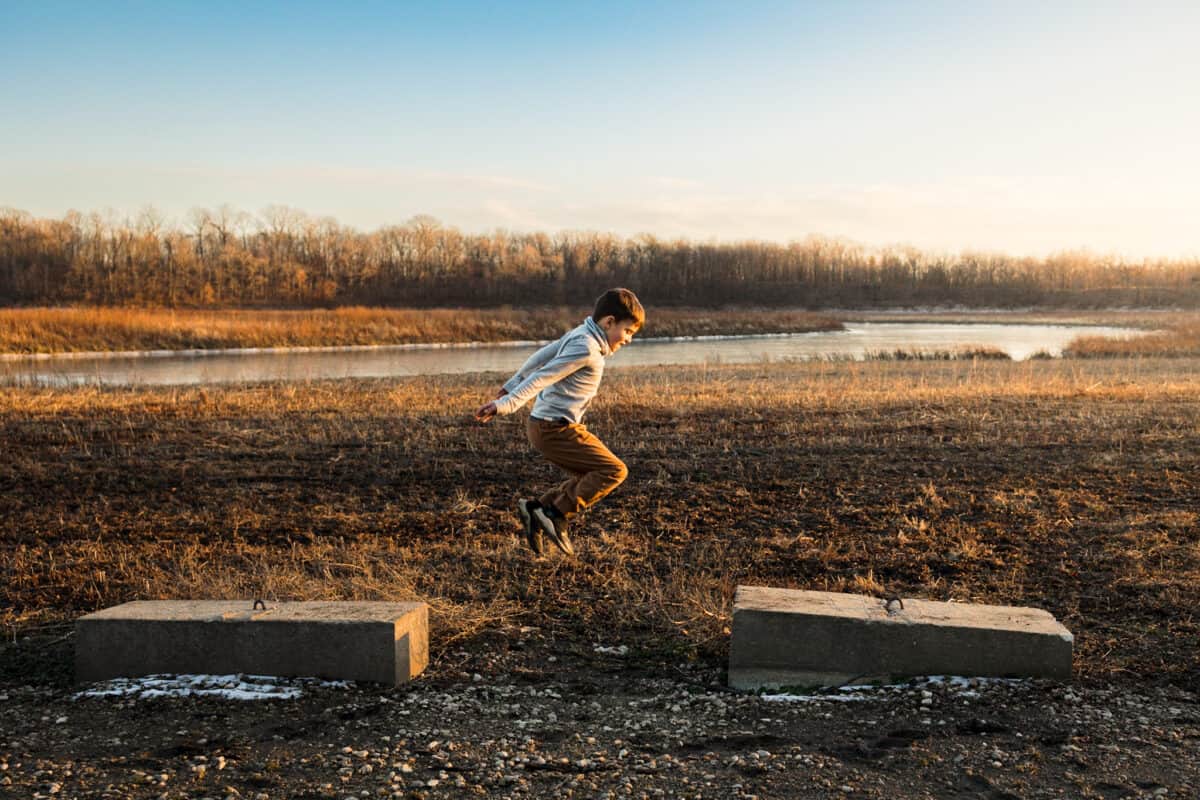 Child jumping - the importance of raising confident kids and how you can do that through outdoor activities