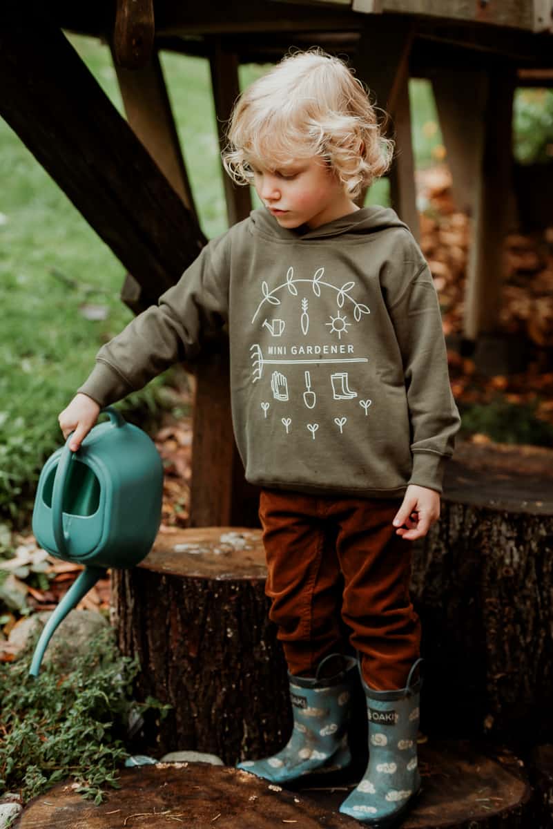 Child giving new seedlings a drink with the watering can. - Tips for getting kids involved in garden tasks