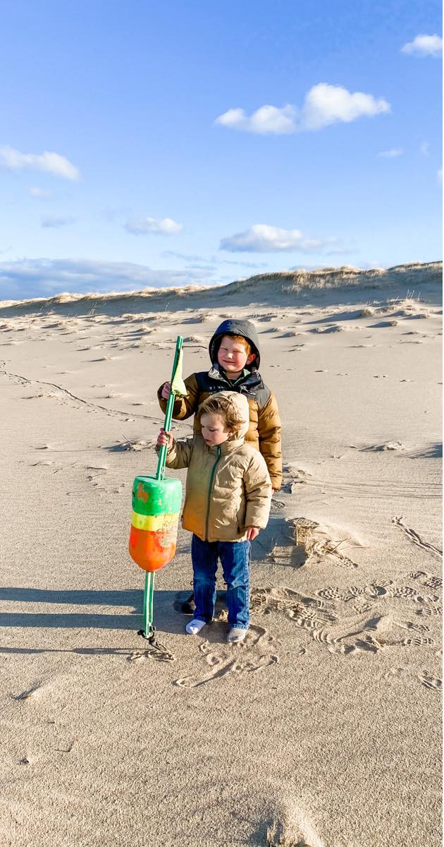 using a buoy as a hiking stick on the beach