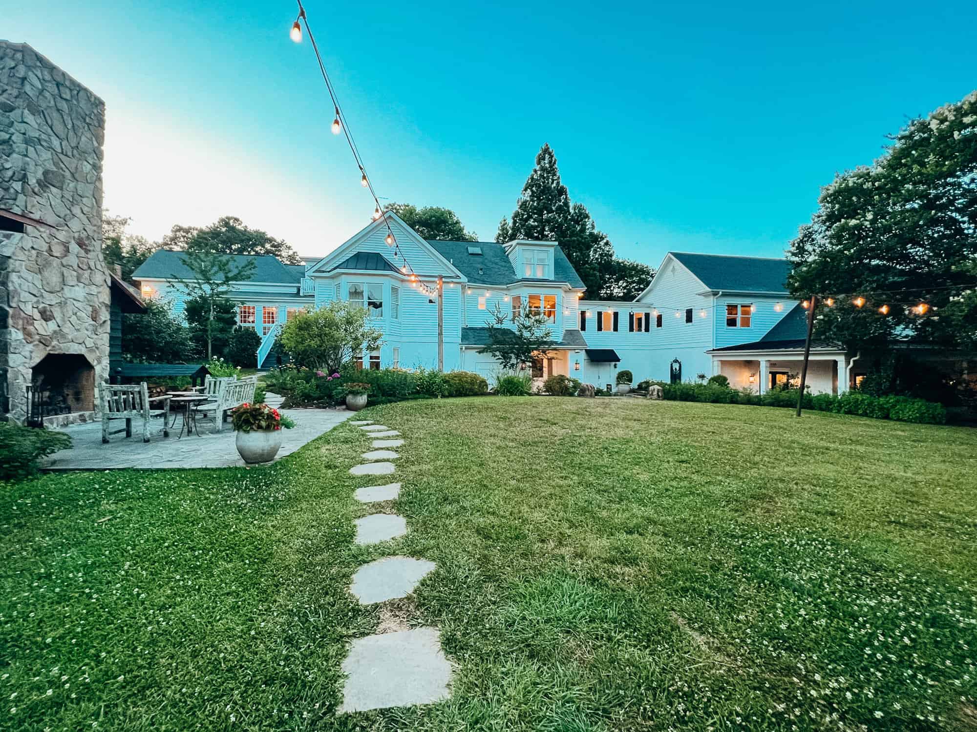 wide view of a country inn with stone footpath and twinkle lights