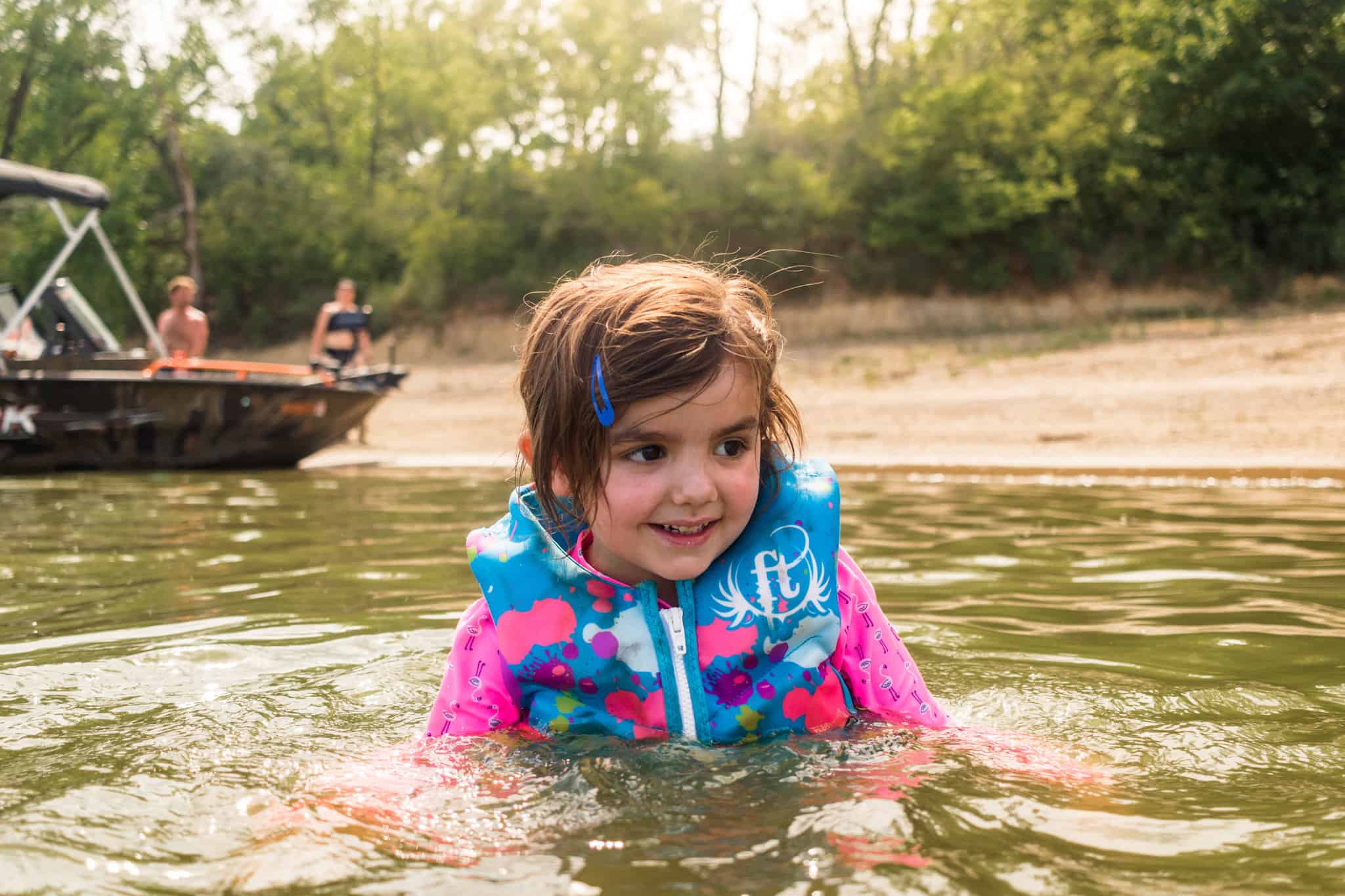 Child in pink and blue life jacket 