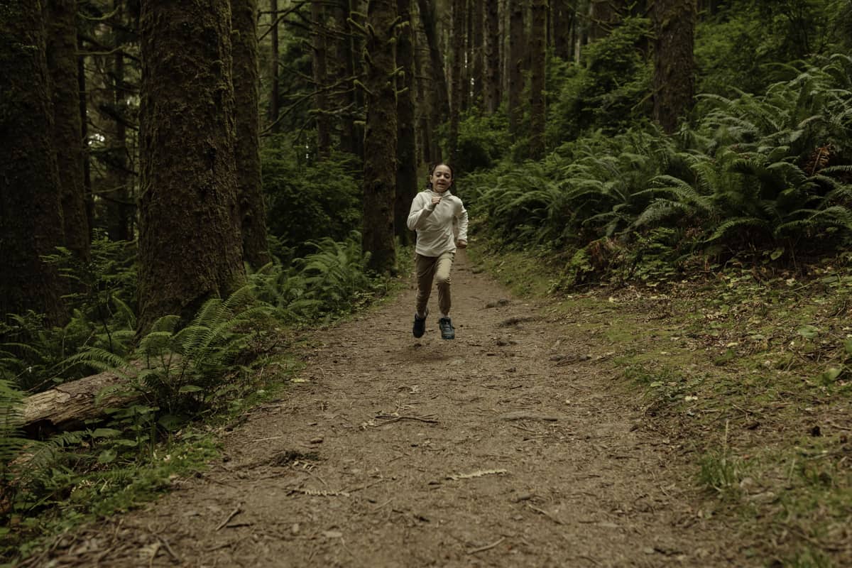 Exploring Fern Canyon with kids - California redwoods - kid running down hiking trail surrounded by towering redwoods