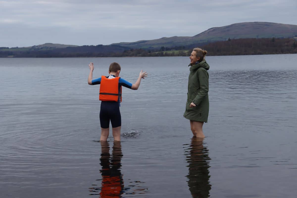 lake in winter, two people in water