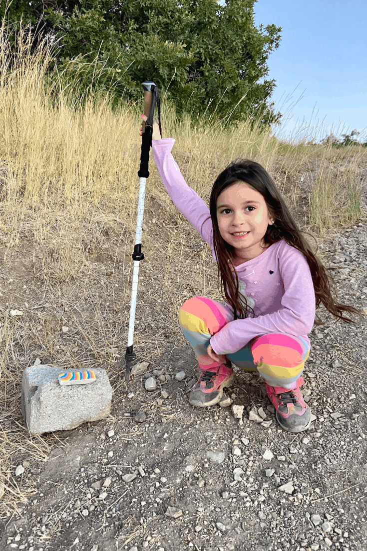 Child hiking and leaving painted rocks on a trail